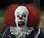 Static pixelated image of a clown with white face paint, red hair, and open mouth against dark background.