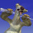 Pixelated static image of a cartoon dog with open mouth and tongue, holding two brown objects against blue gradient background.