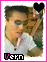 A person in a white shirt with a cigarette, framed by pink border and black heart symbol, text 'Vern' below.