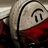 Pixelated character with light brown hair and red clothing, smiling with closed eyes in a static pose.
