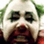 A close-up of a character with white face paint, green hair, and red lips in a static pose.