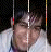 A person with dark hair and a light-colored shirt appears in showing subtle facial expression changes against a black background