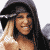A pixelated animated icon shows a woman with long blonde hair and a dark hooded garment, smiling with her hand near her face, transitioning between expressions and partial text overlays.