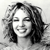 A grayscale pixelated portrait of a person with long hair, closed eyes, and a slight smile, set against a light background.
