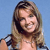 A pixelated image of a person with long brown hair smiling against a light blue background.