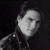 A pixelated grayscale portrait of a person with dark hair and a high-collared garment on the left, next to green text reading 'Original Icons .com' on a solid green background.