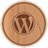 Circular wooden-textured icon with a dark brown WordPress logo at center, surrounded by a thin brown border on light gray background.