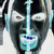 Pixelated static icon of a stylized face with teal and black color scheme, featuring geometric shapes for eyes and mouth against dark background.