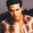 Pixelated image of a person with dark hair wearing a light-colored shirt, set against a muted background.