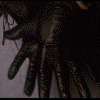 Animated sequence showing black-gloved hands holding a crystal ball, transitioning to reveal a person with spiky blonde hair and dark clothing against a dark background.