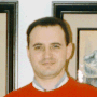 A person in a red sweater with a light gray collar appears in four rotated positions against a background of framed artwork.