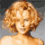 Static pixelated image of a person with curly blonde hair and light skin tone against a gray background.