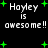 Pixelated text 'Hayley is awesome!!' with green plus signs on black background, repeated in two with slight variations in spacing and plus sign placement