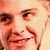 Pixelated close-up of a person's face showing eyes, nose, and mouth with warm skin tones and brown hair strands visible.