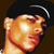 Pixelated static icon of a person's face with dark hair and light skin tones, featuring visible facial features like eyes, nose, mouth, and ear under low-resolution rendering.