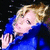 A person with blonde hair in a blue jacket against a dark background, shown across where the head position shifts slightly left to right