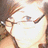 Pixelated close-up of a person's face with light skin, brown hair, and dark eyes against a bright background.