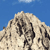 Pixelated mountain peak with rocky texture against blue sky background, rendered in low-resolution style with visible pixelation.