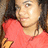 Pixelated close-up of a person wearing red clothing with dark hair and light skin, cropped to show upper body.