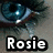 A close-up of a blue eye with visible eyelashes and a light reflection, with the name 'Rosie' displayed below in white text on a black outline.