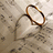 A pixelated heart-shaped icon with a brown outline and white fill, set against a light beige background with scattered darker pixels.