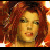 Pixelated portrait of a person with reddish-brown hair and warm-toned skin, set against a blurred background of orange and brown hues.