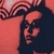 Pixelated static image of a person with dark hair and a dark top against a reddish-pink background, showing partial facial features and a curved shape above the head.