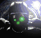 Animated sequence of a dark helmeted figure with glowing green eyes and mouth, set against a bright background with light streaks.