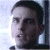 Pixelated close-up of a person's face with dark hair, light skin, and visible eyes, nose, and mouth against a light background.