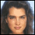 Static pixelated image of a person's face with long dark hair against a light background, rendered in low-resolution style typical of early internet buddy icons.