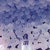 Pixelated abstract composition of blue and white tones with scattered dark fragments against a gradient background.