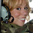 Static 48x48 pixel icon showing a close-up of a person with light brown hair and fair skin, wearing dark clothing with visible patterns, against an indistinct background.