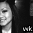 Pixelated grayscale image of a person's face with closed eyes and subtle smile, set against dark background with 'wk' text in bottom right corner.