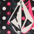 A pixelated icon features a white and pink figure with flowing hair against dark background, surrounded by scattered red and white circular shapes.