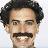 Static 48x48 pixel icon showing a close-up of a person's face with dark curly hair, mustache, and neutral expression against light background.
