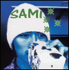 A 4-frame animated contact sheet showing a person wearing a white beanie with green text, holding a white object near their face against a blue background with small green star-like symbols.