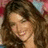 A pixelated image of a woman with long brown hair smiling, with a pink 'C2' symbol in the top right corner.