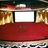 A static image of a red theater seat with a white screen and golden curtains in the background.