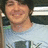 A pixelated image of a person in a light blue shirt with a graphic, overlaid with orange text on black and gray backgrounds.