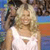 Pixelated image of two people in close proximity, one wearing a white sleeveless top with a small triangular design, against a blurred background with blue and brown tones.