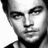 Black-and-white pixelated portrait of a person with short dark hair, wearing a collared shirt and tie, cropped to show shoulders and upper chest.