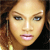 Pixelated close-up of a person's face with light brown hair, blue eyes, and pink lips against a dark background.