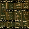 A static image of vertical golden-brown with greenish-brown hieroglyphic symbols, overlaid with pixelated text reading "my fandom has symbols that your fandom won't understand not even up close"
