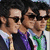Three identical figures in dark suits and sunglasses appear side-by-side with green text reading 'arent they SEXY' above and purple text reading 'with their sunglassess' below.