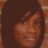 A person with dark hair and a brick wall background appears in a of four , with the bottom-right blank