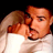 Static pixelated image of two people in close physical proximity with one person's face partially visible and the other person's back turned, rendered at low resolution on a black background.