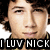 Pixelated close-up of a person's face with dark hair, wearing a black shirt and white text reading 'ILUV NICK' at the bottom.