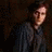 A pixelated image split into two sections: a person in dark clothing on the left and text with star shapes on the right.