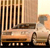 A pixelated static image shows a vintage car with a driver, set against a striped background with vertical lines and a light gradient.