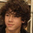 Pixelated image of a person with curly brown hair on left, blue background with pixelated text reading Mrs Nick Jonas and Its Called LOV3.